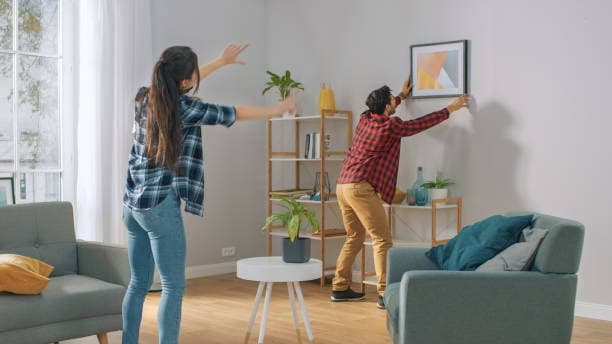 Dos persona decorando una habitación.